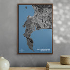Cape Peninsula and Robben Island Granite map print in a brown frame, hung above a shelf with ornaments