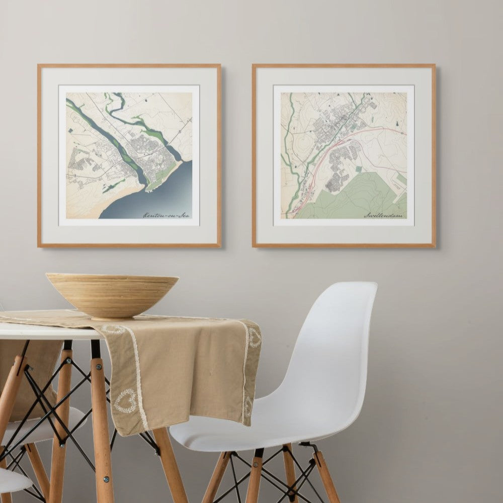 Two framed classic maps of Kenton-on-Sea and Swellendam in dining setting, a table with white chair