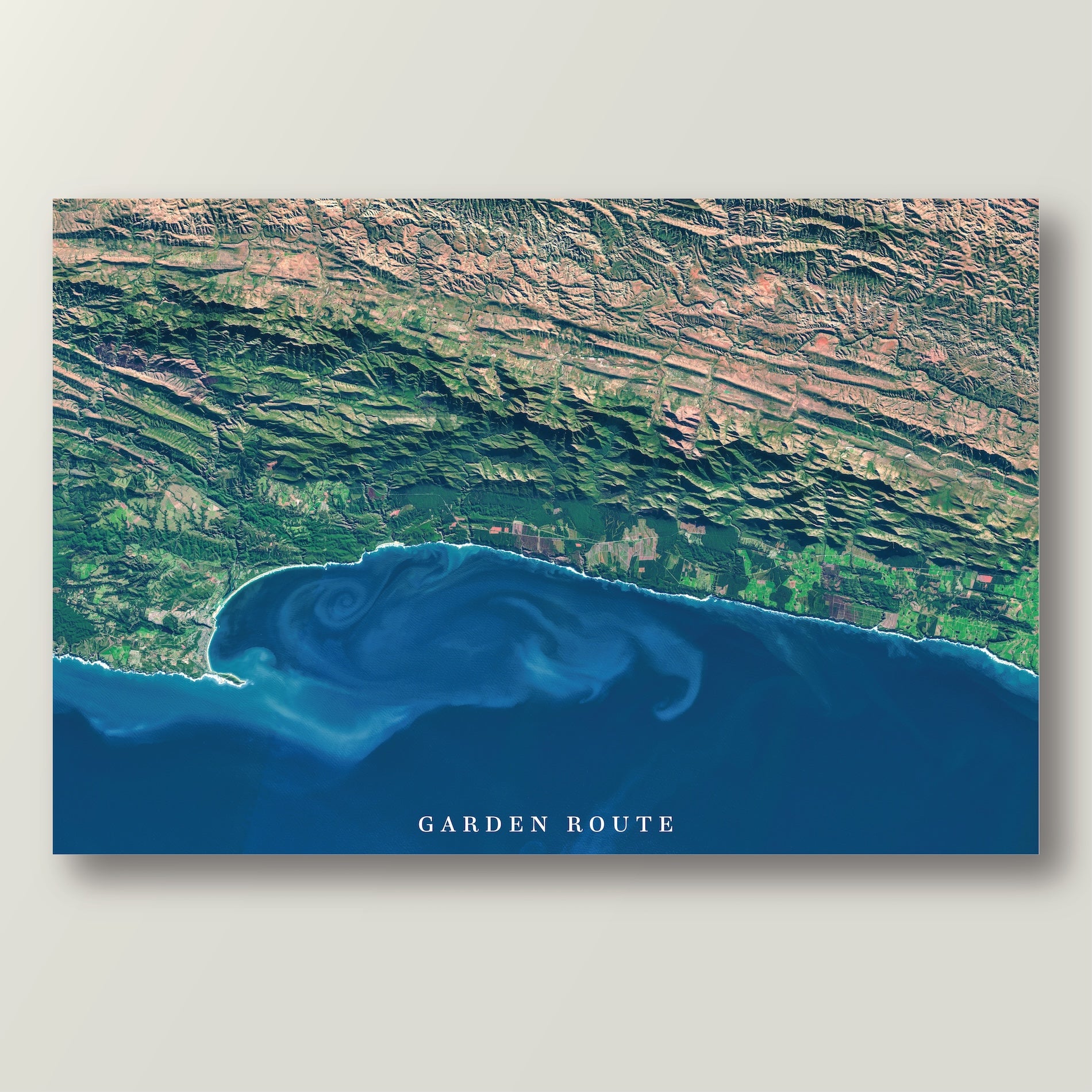 Garden Route 2 East satellite print in the Titled style, showing the coast from the Robberg Peninsula to the Tsitsikamma Mountains, with deep blue water and ocean currents, and the title Garden Route on the image