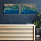 Pair of Garden Route satellite prints — Garden Route 2 West and East — framed side by side on a dark blue wall above a reception desk.
