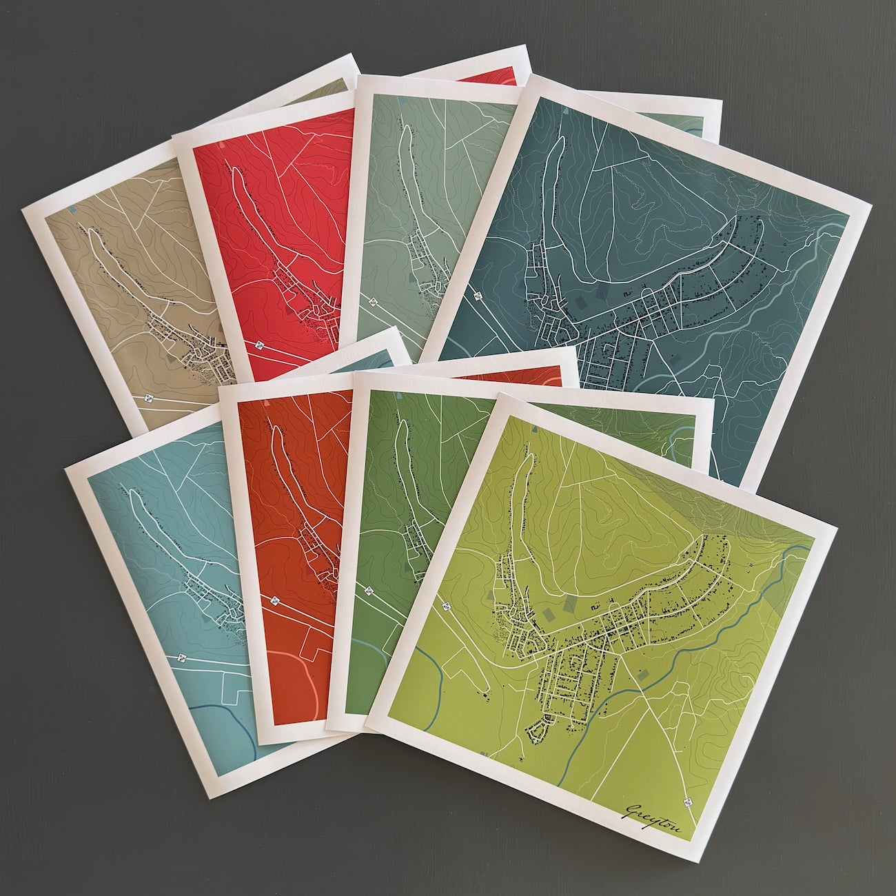 Fanned out display of Greyton maps in different colourways.