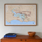 Knysna large map print in the Vintage style, in a warm oak frame with a white mount, hung above a wooden chest